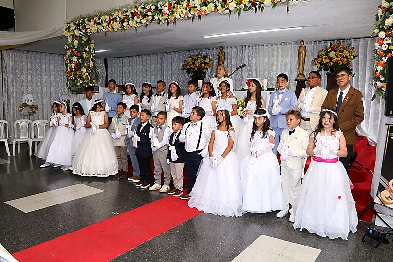 Comunidad católica del Gimnasio del Corazón de María celebrando la Primera Comunión